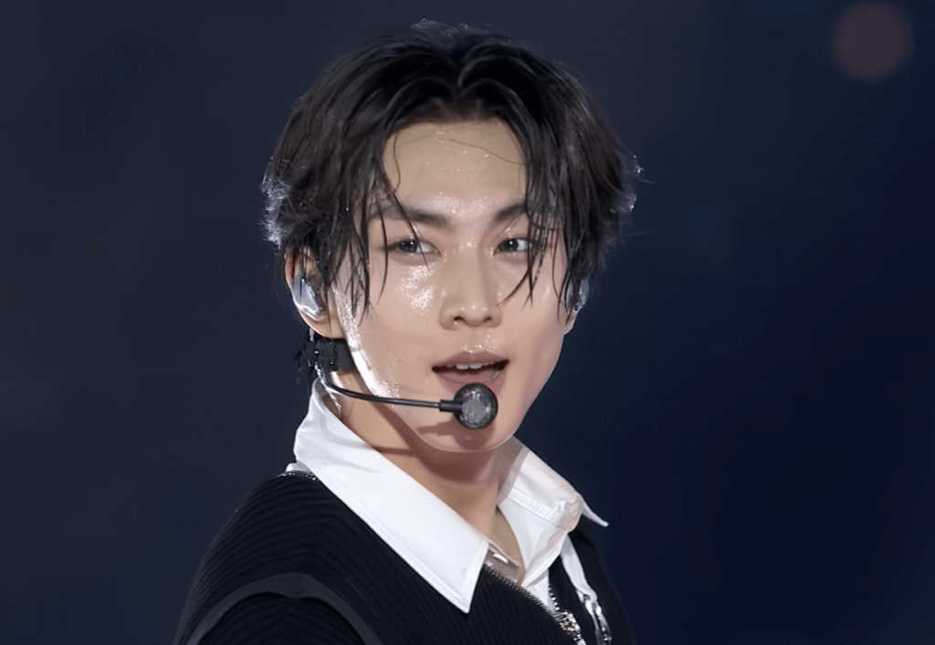 Jungwon du groupe Enhypen en sueur après une performance intense, symbolisant la discipline et l'effort physique des Trainees K-POP.